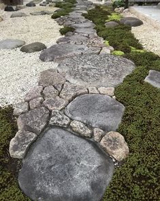 a stone path with moss growing on the sides and rocks in the middle that lead up to it