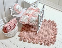 a crocheted baby bed and blanket set on the floor next to a white rocking chair