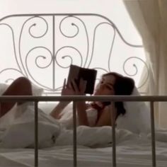 a woman laying in bed reading a book