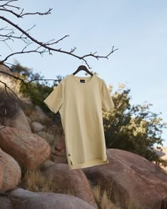 a t - shirt hanging on a clothes line next to some rocks