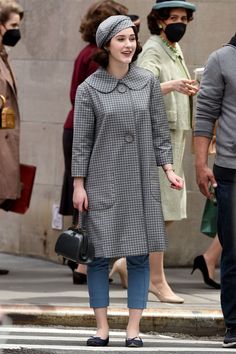 a woman is walking down the street wearing a face mask