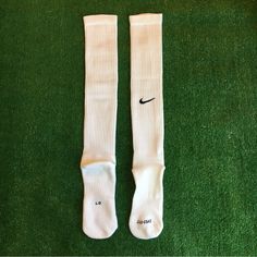 a pair of white socks with the word nike written on them sitting on green grass