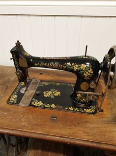 an old sewing machine sitting on top of a wooden table