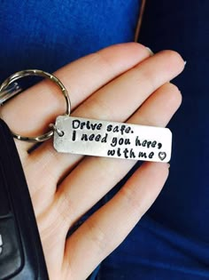 a person holding a keychain that says drive safe i need you here with me