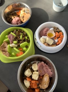 three bowls filled with food on top of a table