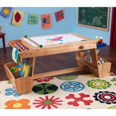 a child's drawing table with storage bins