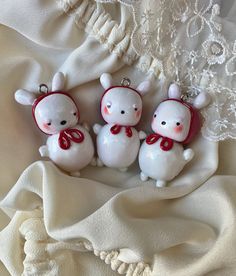 three little white bears with red bows on their heads are sitting next to each other