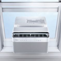 an air conditioner sitting on top of a window sill in front of a blue sky