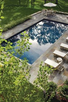 an empty swimming pool surrounded by lawn chairs