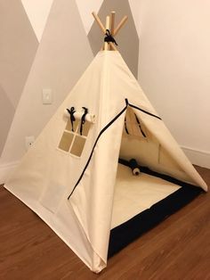 a teepee is sitting on the floor in front of a wall