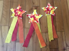 three paper stars are on the floor next to each other with ribbons tied around them