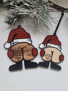 two wooden ornaments with santa hats on them