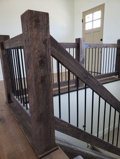 a wooden banister next to a door in a house