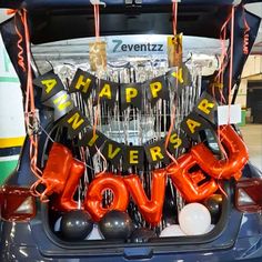 the trunk of a car decorated with letters and balloons