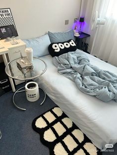 a bed sitting next to a table with a pillow on top of it