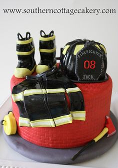 a birthday cake for a fireman with boots and equipment on the top, sitting on a plate