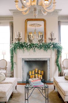 a living room filled with furniture and a fire place covered in greenery next to a fireplace