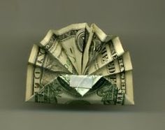 an origami dollar bill folded into a paper plane with the money coming out