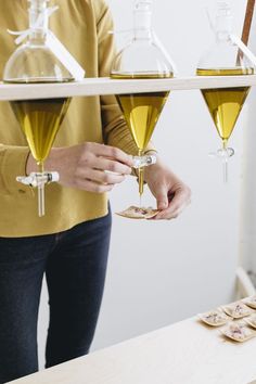 two people holding wine glasses in front of each other on a shelf with small cookies