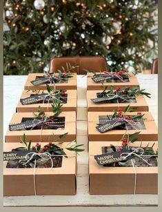 several boxes are wrapped in brown paper and tied with twine ribbons, sitting on a table next to a christmas tree