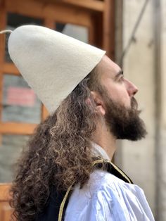 a man with long hair wearing a white hat