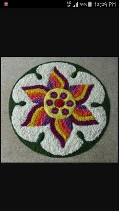 a white and green rug with a colorful flower on it