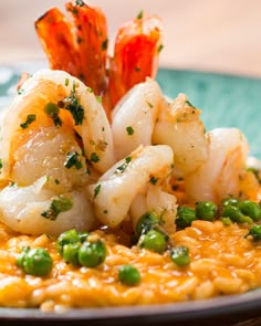 a plate with shrimp, peas and rice on it