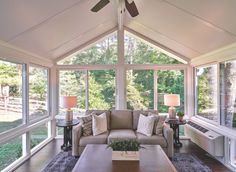 a living room filled with furniture and windows covered in white coverings on the ceiling