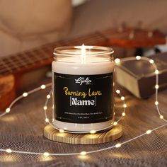 a candle sitting on top of a table next to a string of lights and a guitar