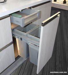 an open refrigerator door in a kitchen with wood flooring and white counter top cabinets