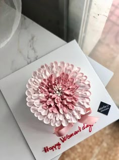 a pink flower on top of a white card with the words happy women's day