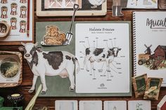 an assortment of farm related items displayed on a wooden table with cards and magnets