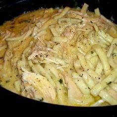 pasta with chicken and parmesan cheese in a black pan on the stove top