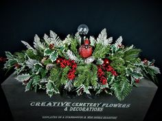 a christmas centerpiece with holly, berries and pine cones on it's base