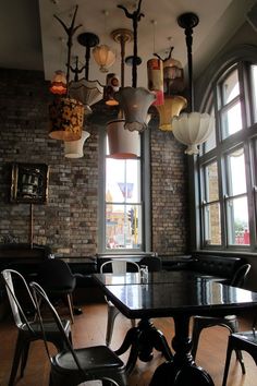 a restaurant with large windows and lots of lights hanging from the ceiling