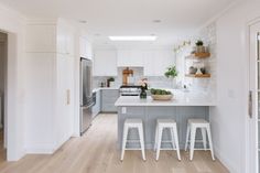 a kitchen with white walls and wooden floors