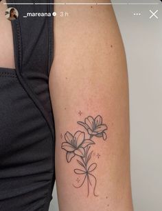 a woman with a flower tattoo on her left arm and the other arm behind her