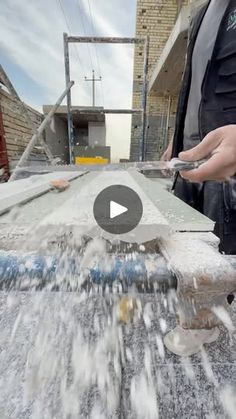 a person standing on top of a roof with water pouring out of the gutter