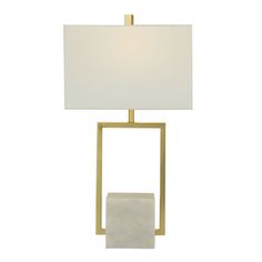 a table lamp with a white shade on the top and a gold frame around it