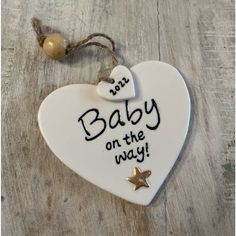 a ceramic heart ornament that says baby on the way