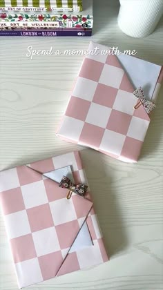 pink and white checkered wrapping paper with a cross on it, next to a stack of books