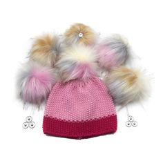 a knitted hat with two pom poms on the front and one in the back