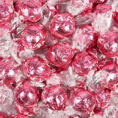 pink chocolate candies wrapped in clear cellophane and sitting on top of each other