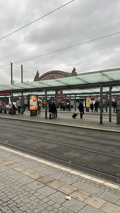 people are waiting at the train station for their trains