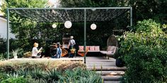 two people sitting on a bench in the middle of a garden