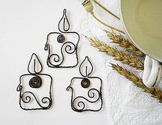 four wrought iron candle holders sitting on top of a white towel next to some wheat stalks