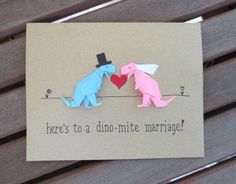 there is a card with two origami dinosaurs on it that says here's to a dino - mitte marriage