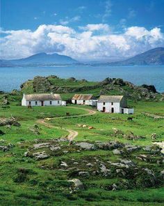 an island with two houses on it and water in the backgrounds