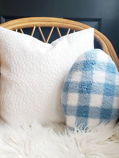 a blue and white pillow sitting on top of a bed