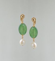 Natural pearl, green jade and cultured pearl dangle earrings. A little vintage chic for these mid-length dangling earrings, made with a pretty semi-transparent oval pearl with slightly faceted contours. A pretty, slightly irregular round cultured pearl forms a mobile pendant. Only one more available in clip-on or pierced ear versions. ** Materials ** Freshwater pearl.  Freshwater pearl. Jade. Gold-plated brass clips or studs (European manufacture), guaranteed nickel-free. Total height: 4.5 cms approx. ** Shipping ** Gift wrapping available on request. The cost of mail shipments followed is free. To take good care of your accessories, I advise you to keep them away from light, humidity and wipe them gently with a small microfiber square. For jewelry with natural pearls, it is best not to pu Pretty Earrings Dangle, Pierced Ear, Vintage Clip On Earrings, Ear Earrings, Jade Earrings, Natural Pearl, Pearl Earrings Dangle, Dangling Earrings, Semi Transparent